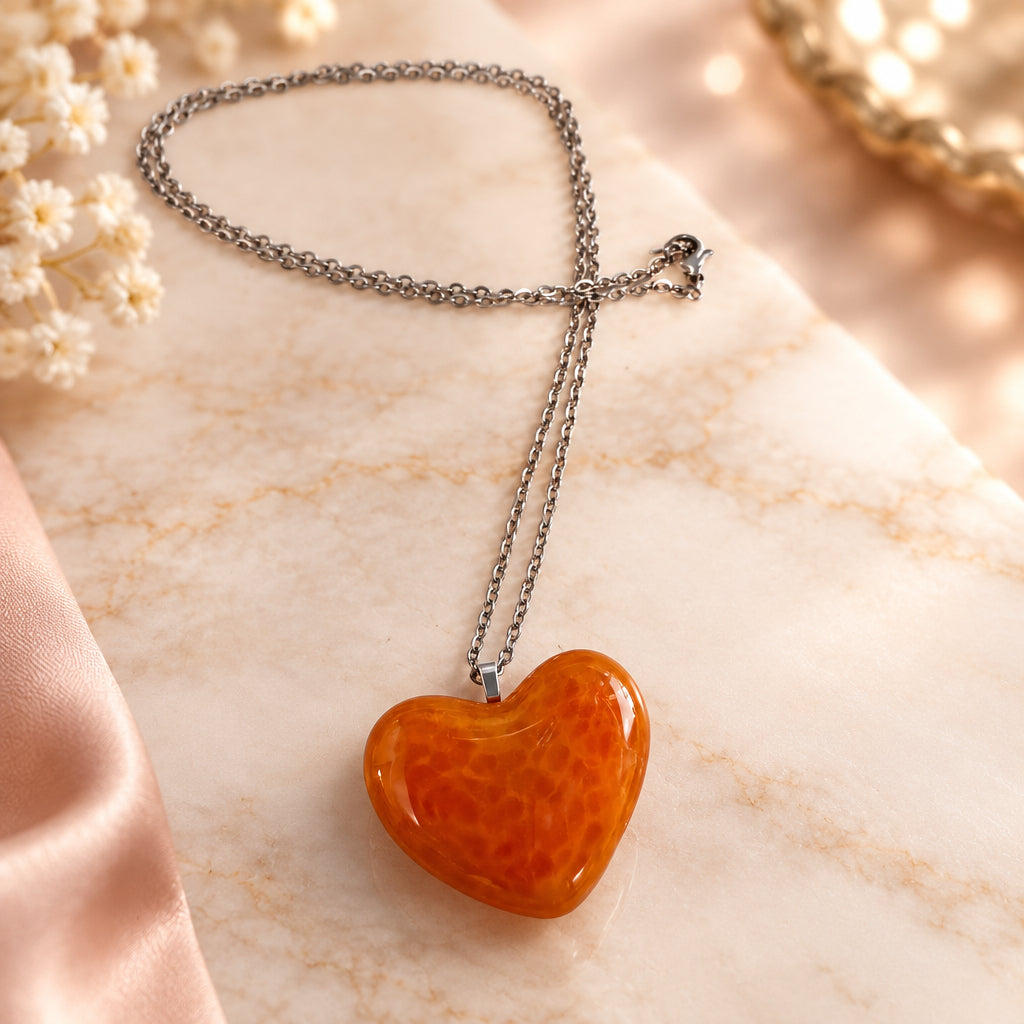 Orange glass heart pendant on a silver-tone chain