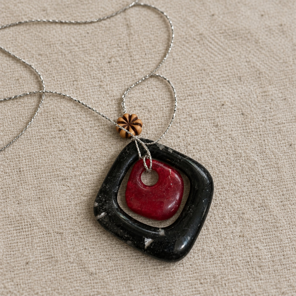 Black open-square glass pendant with red center detail on a silver-tone chain