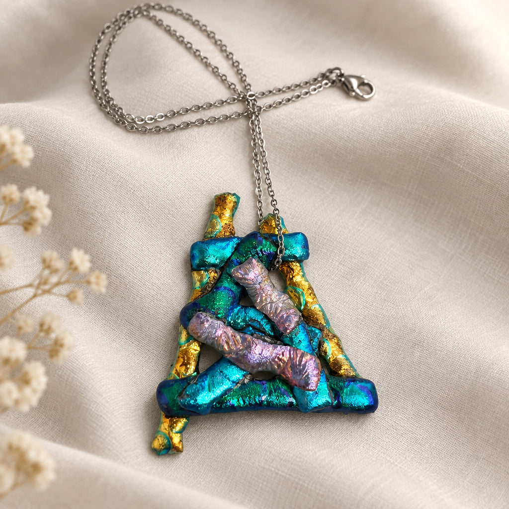 Geometric glass pendant with turquoise, gold, and pink layers on a silver-tone chain