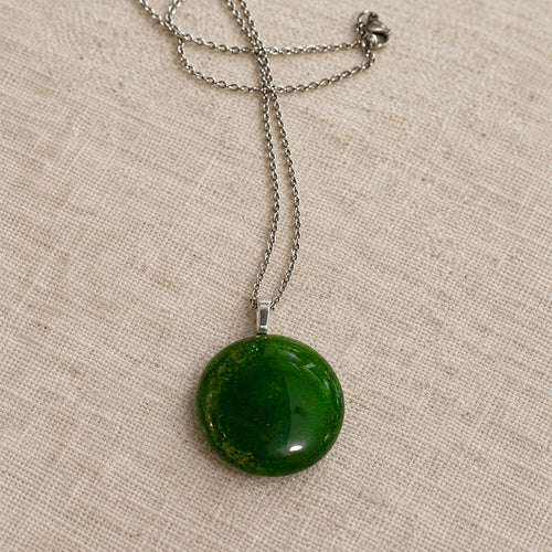 Plain dark green circular glass pendant on a silver-tone chain