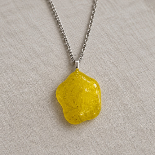 Yellow flower-shaped glass pendant on a silver-tone chain