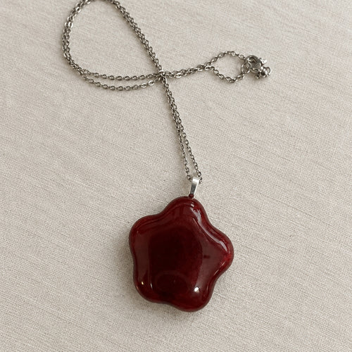 Deep red flower-shaped glass pendant on a silver-tone chain